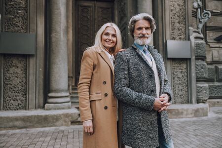 Happy adult couple is standing together outdoorsの写真素材