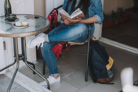 Young woman is sitting in cafe outdoorsの写真素材