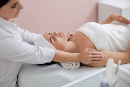 Smiling young woman enjoying massage stock photoの写真素材