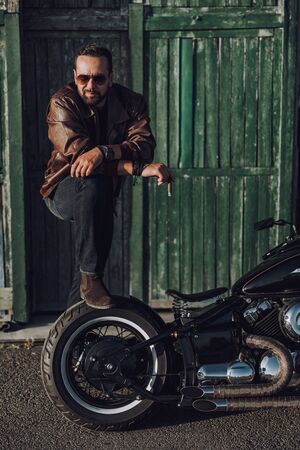 Handsome biker is posing for camera outdoorsの写真素材