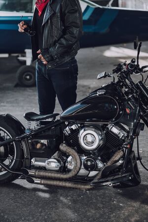 Caucasian motorcyclist having rest in garage indoorsの写真素材