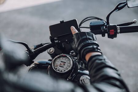 Cropped photo of motorcyclist sitting on classical motorbike outside stock photoの写真素材