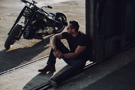 Thoughtful adult man spending time in garageの写真素材