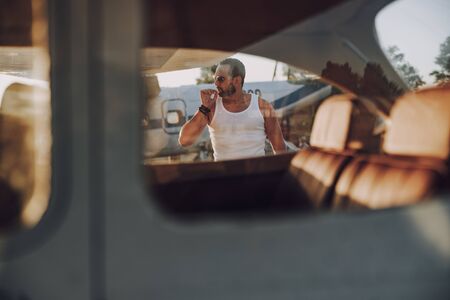 Thoughtful guy in sunglasses having rest outdoorsの写真素材