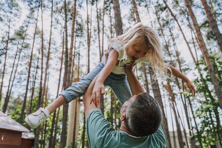 Father lifting his daughter up in the airの写真素材