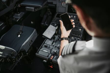 Missing home. Man in uniform reading message on mobile phone stock photoの写真素材