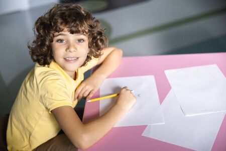 Jolly kid having fun in games room stock photo