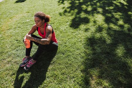 Beautiful Afro American lady sitting on the grass