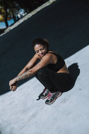 Charming Afro American girl in sportswear resting outdoors