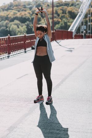 Afro American woman exercising on the bridge