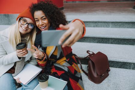 Pretty Caucasian and Afro American women taking selfieの写真素材