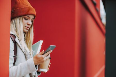 Young female student is using modern smartphoneの写真素材