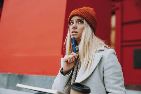Pretty girl learning and holding coffee to go