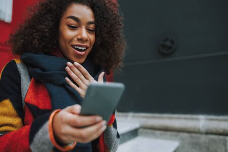 Young Afro American girl using modern smartphone