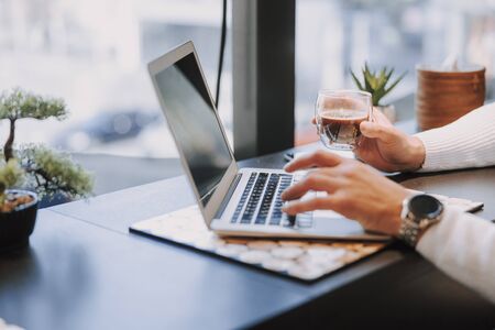 Cropped photo of male worker typing on keyboard and sitting at table in office