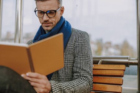 Handsome stylish man reading notes on the streetの写真素材