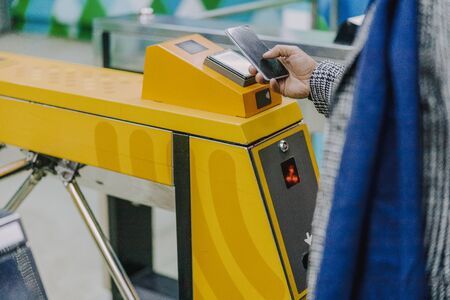 Young man using smartphone to pay for public transportの写真素材