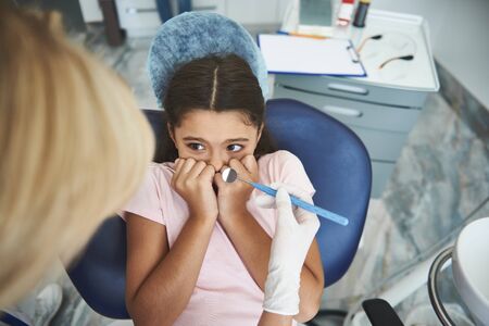 Girl is scared of dental procedures in clinicの写真素材