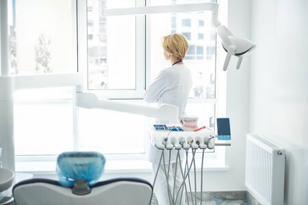 Experienced adult dentist is relaxing during breakの写真素材