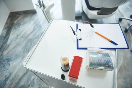 Dental instruments and clipboard are left on table