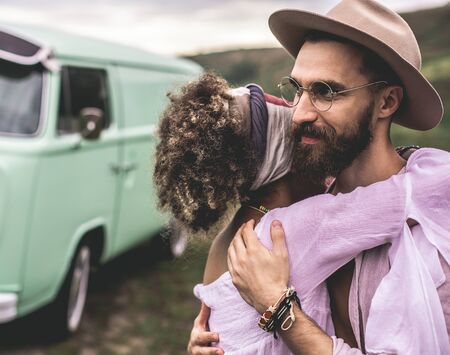 Beloved ethnicity couple embracing on nature hillsの写真素材