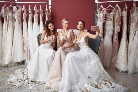 Three brides with champagne glasses making selfieの写真素材