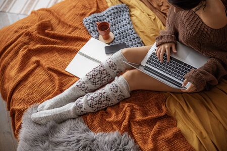 Cropped photo of young woman sitting with laptopの写真素材