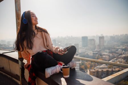 Smiling young female with coffee resting on the roof