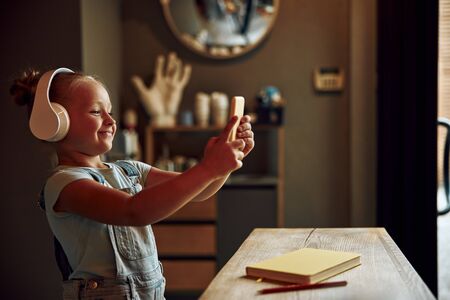 Positive girl talking selfie and smiling