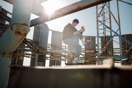Happy guy looking on phone screen on roof