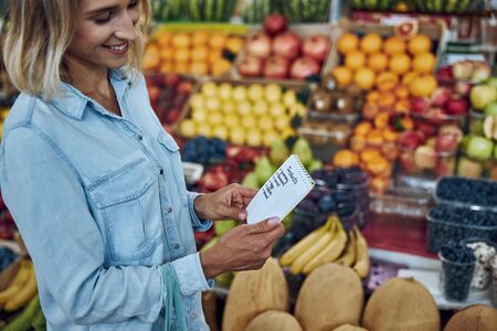 Woman buying food according to her shopping list stock photoの写真素材