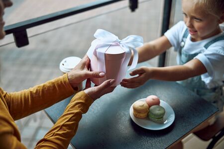 Present in hands of mother and daughter stock photoの写真素材