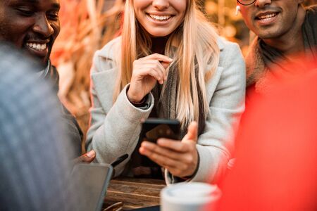 Happy pretty female holding smartphone and looking on screenの写真素材