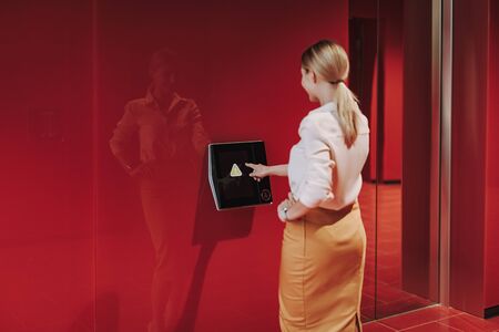 Elegant young woman entering access code on displayの写真素材