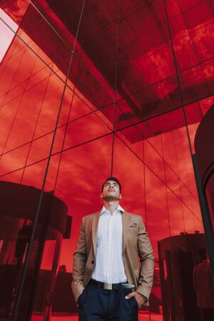 Young elegant man before glass wall stock photo