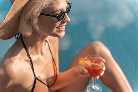 Attractive lady with drink looking away and smiling stock photoの写真素材