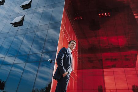 Carefree businessman near modern glass building stock photoの写真素材