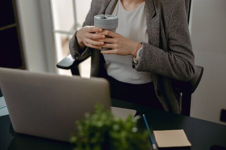 Female hands holding hot drink and restingの写真素材