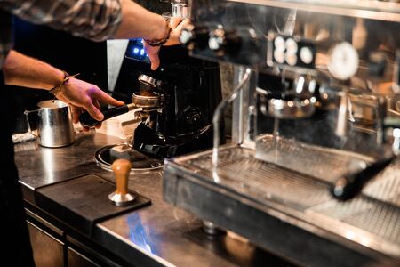 Close up of male waiter making hot drink in cafeteria stock photoの写真素材
