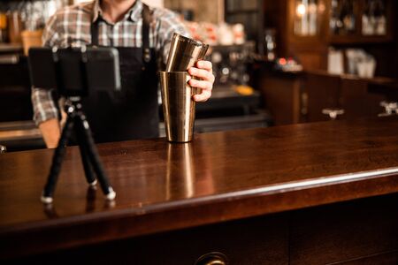 Cropped photo of barman making video while using shaker stock photo