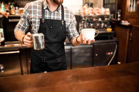 Cropped photo of waiter making latte at bar counter stock photoの写真素材