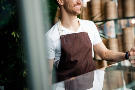 Caucasian bartender is standing near bar counterの写真素材