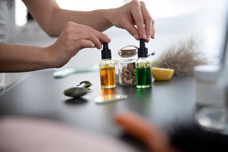 Female hands touching two bottles of vitamin serumの写真素材