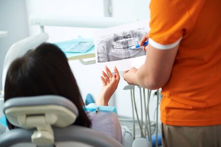 Male dentist is holding results of x-rayの写真素材