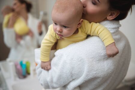 Loving woman kissing her baby
