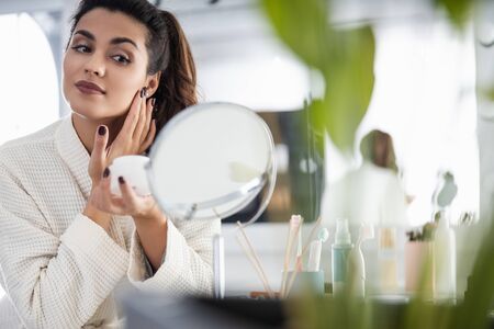 Smiling beautiful woman is holding cream jarの写真素材