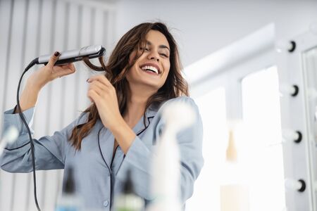 Smiling young lady enjoying morning in bedroomの写真素材
