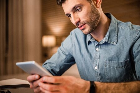 Young man with gadgets at home stock photoの写真素材