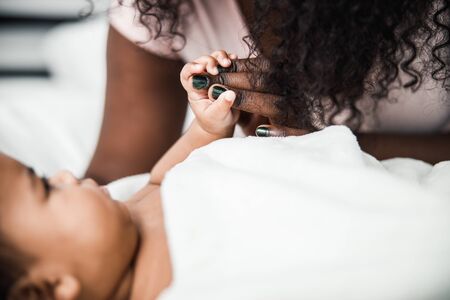 Afro American newborn child holding mother hand