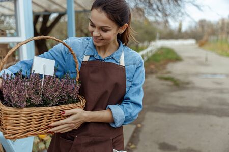 Pleased female botanist enjoying beautiful flowering plantsの写真素材